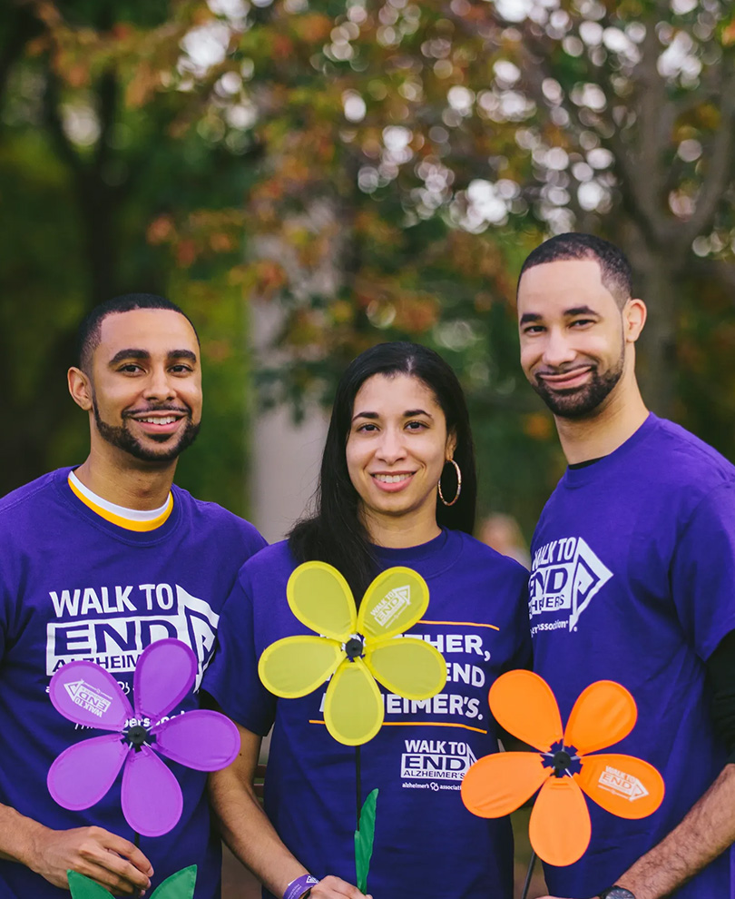 Woman and son's holding flowers that are the logo for Walk to End Alzheimers